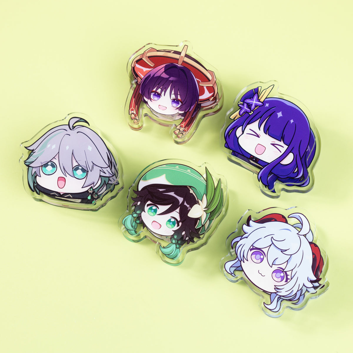 Colorful chibi character acrylic keychains arranged on a light green background.