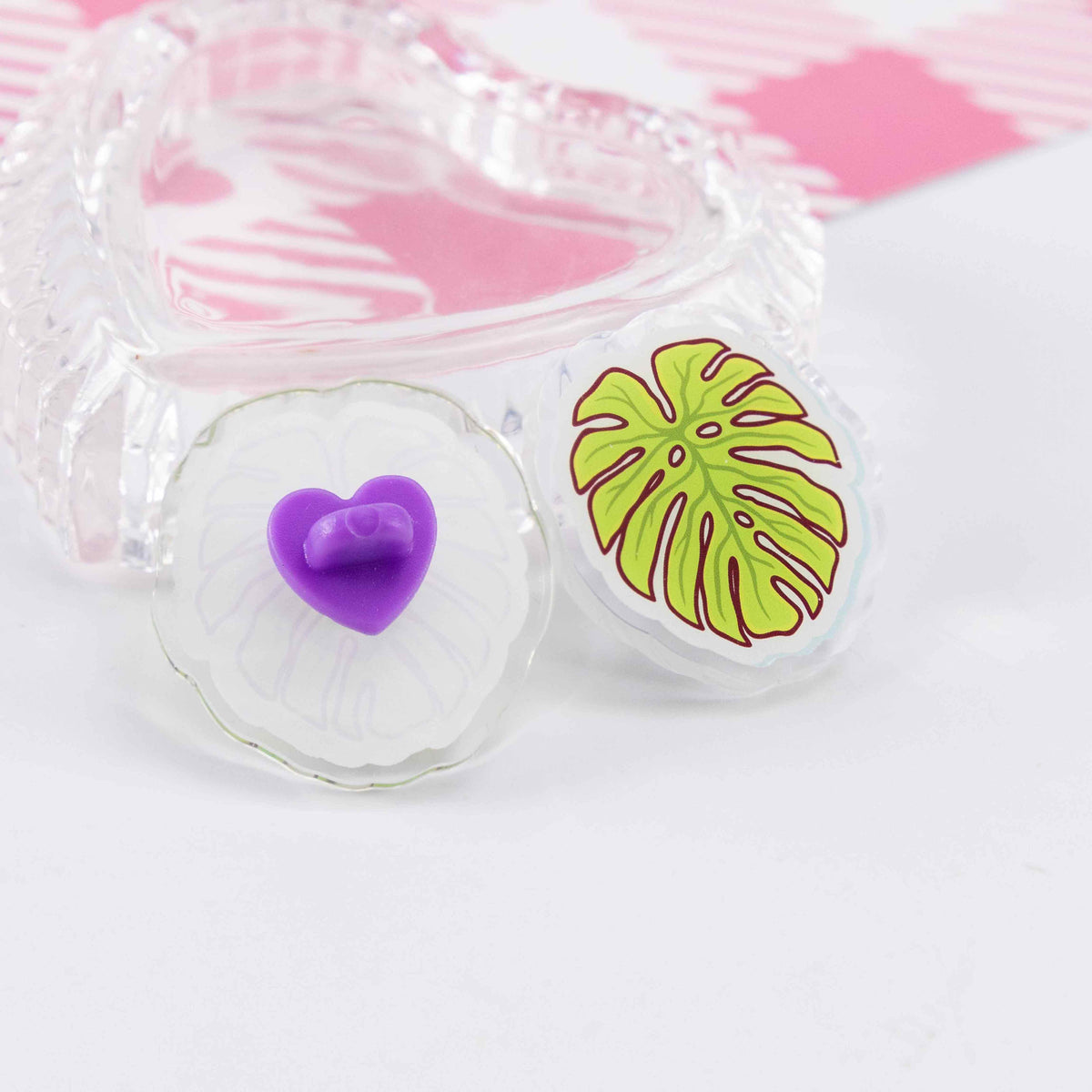 Close-up of a custom transparent acrylic badge: showcasing the details of a cute brooch with a heart-shaped clasp.
