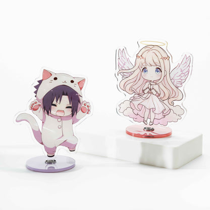 Two custom rotating acrylic standees: desktop ornaments featuring anime-style characters—a chibi boy in a cat onesie and an angel girl.