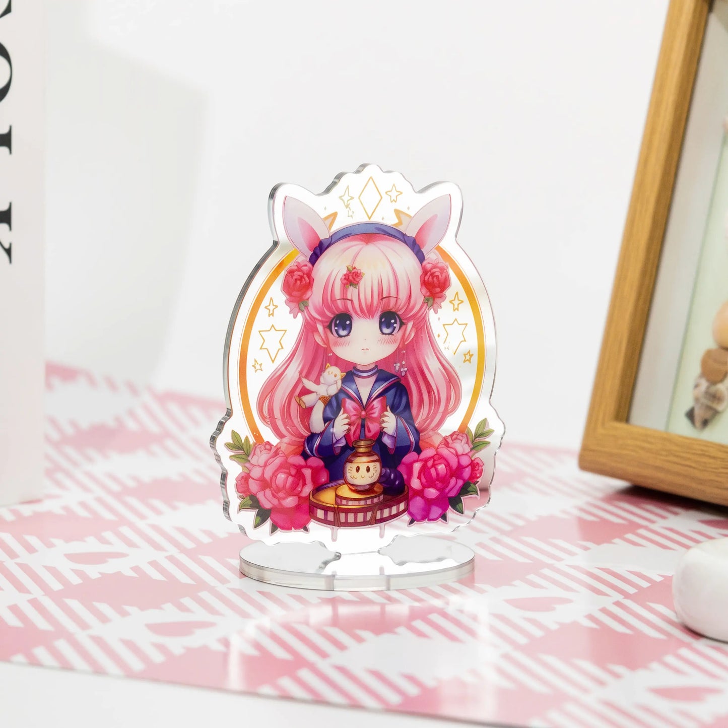Custom acrylic mirror standees featuring anime characters, placed on a pink and white table as desktop decorations.