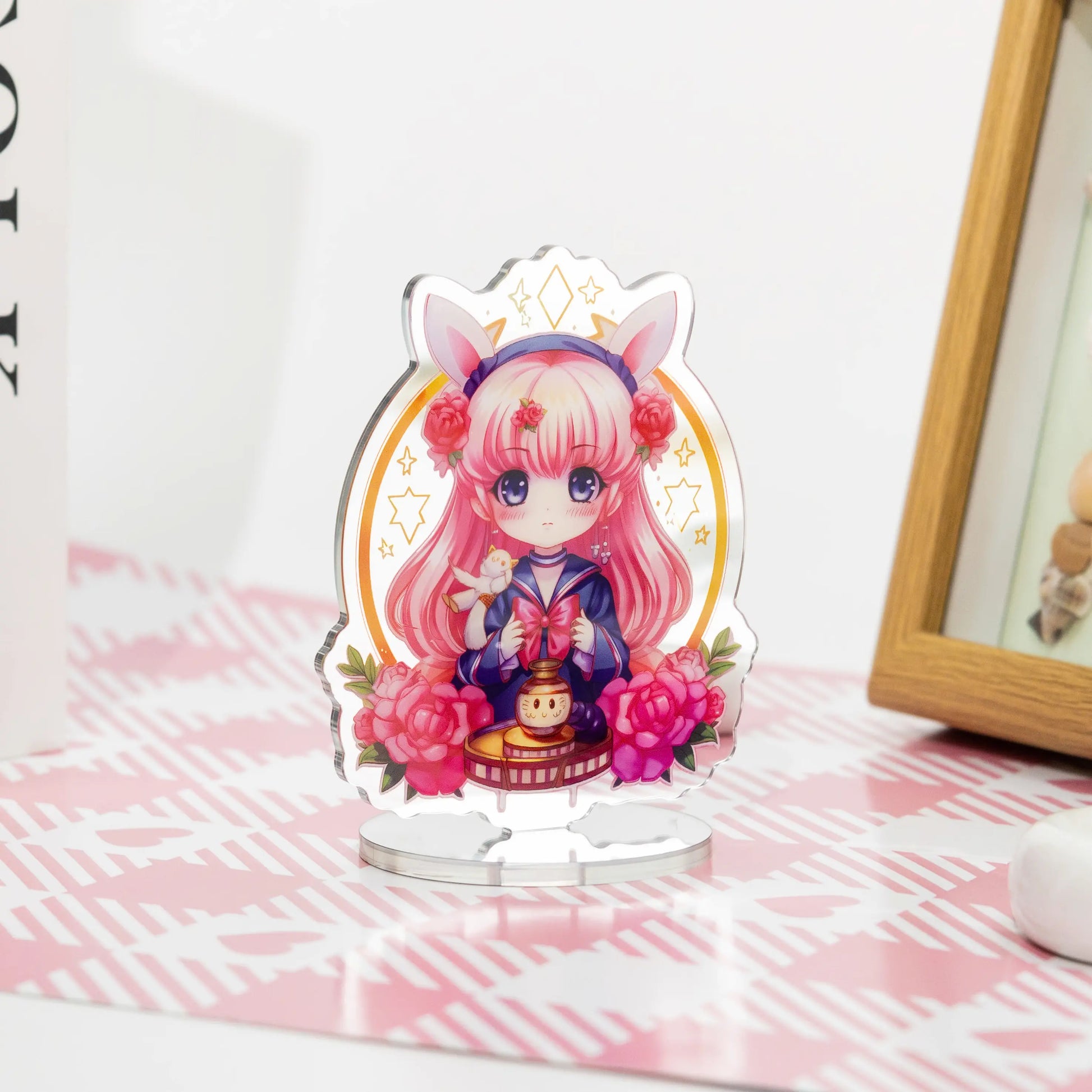 Custom acrylic mirror standees featuring anime characters, placed on a pink and white table as desktop decorations.